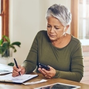 Older woman doing calculations.