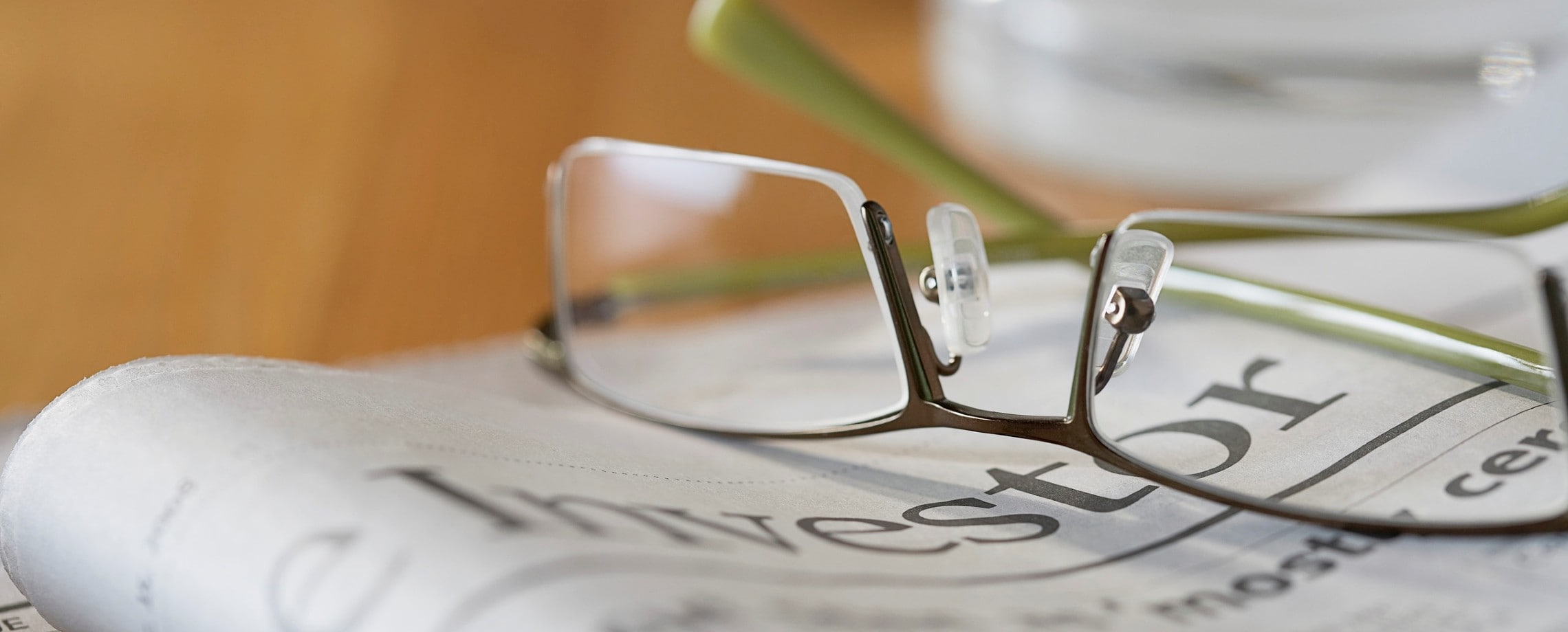 Eyeglasses on top of folded newspaper