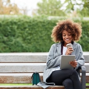 Young adult sitting on park bench.
