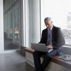 older man studying computer