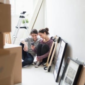young couple taking a moving boxes break