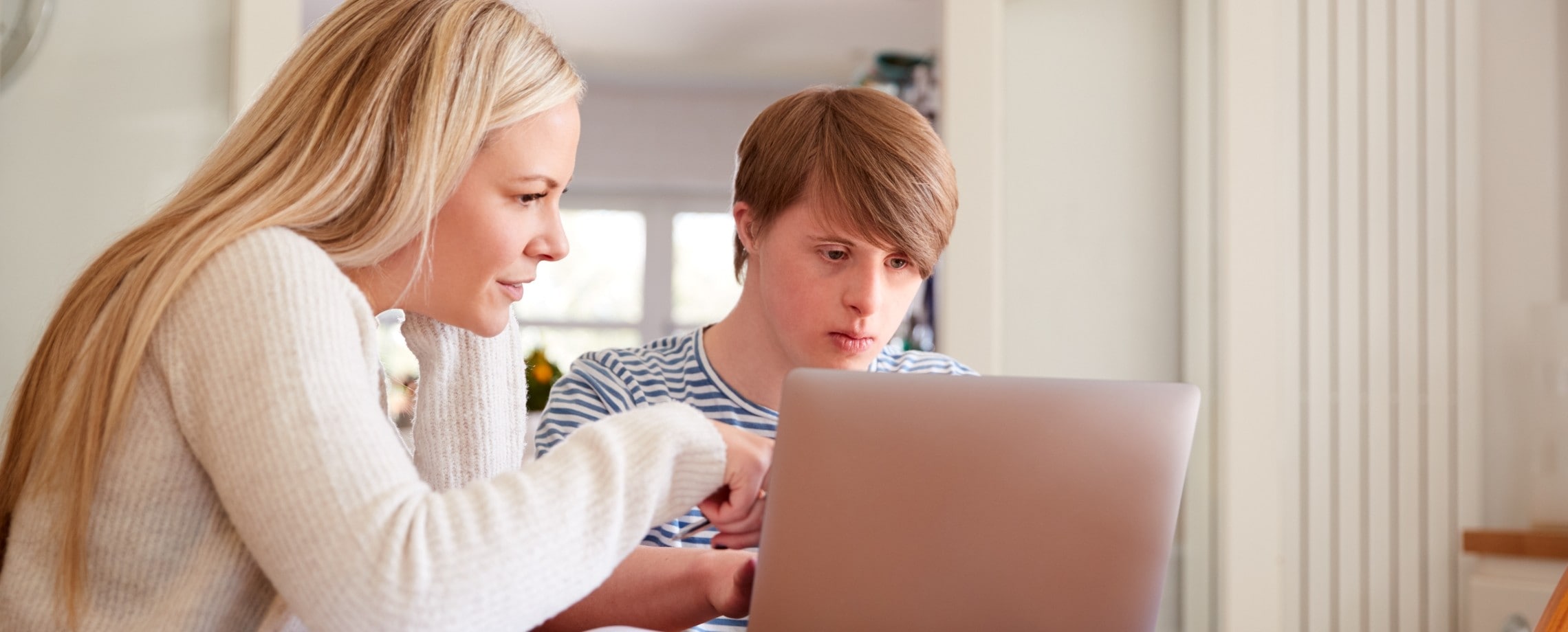 woman computer coaching autistic young man