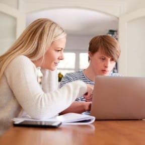woman computer coaching autistic young man