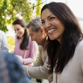 Smiling middle aged Hispanic woman at outdoor family gathering