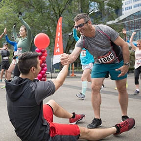 Runners warming up with one man helping another up off the ground