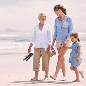Three generations of Caucasian women walking on the beach