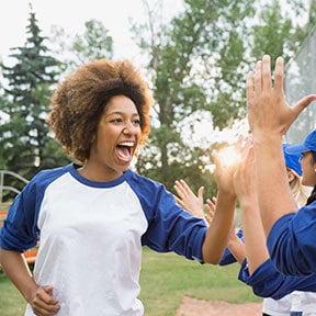 African-American woman giving a 'high-five' to a line of teammates' hands
