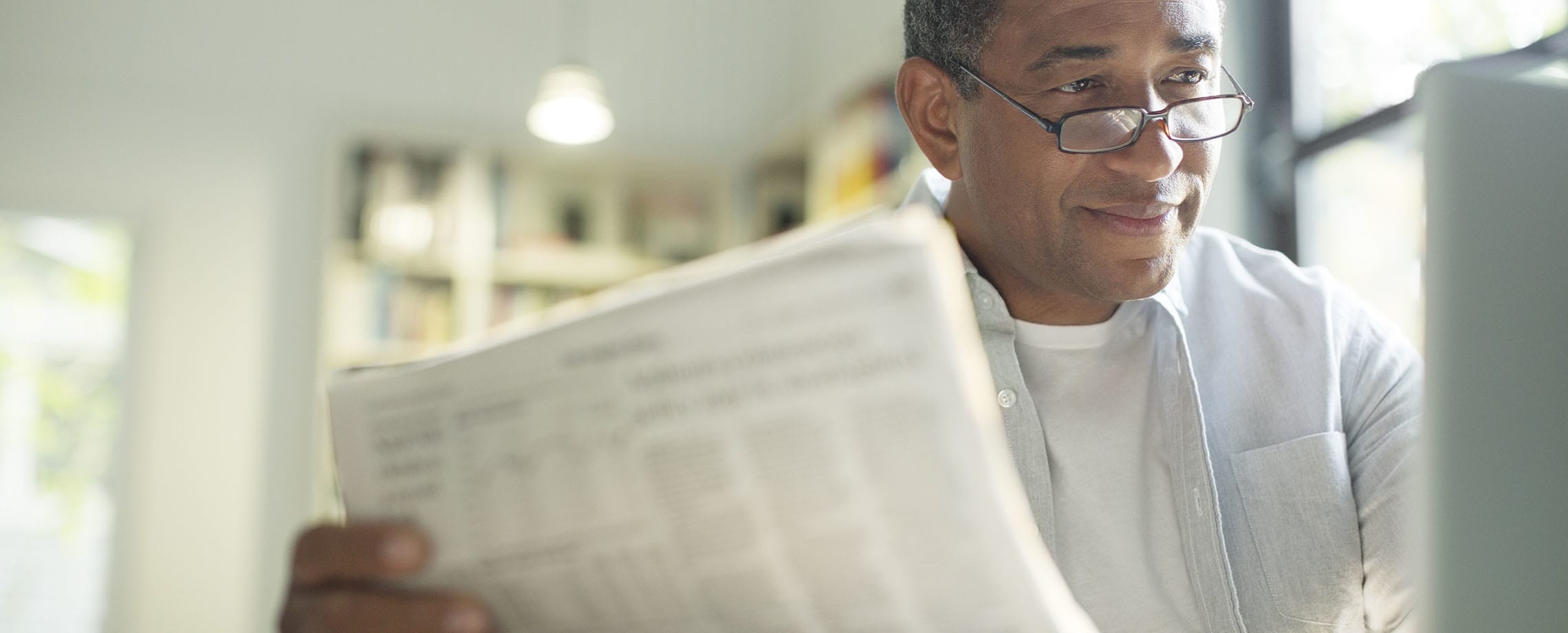 Older African-American man looking at computer while holding paper