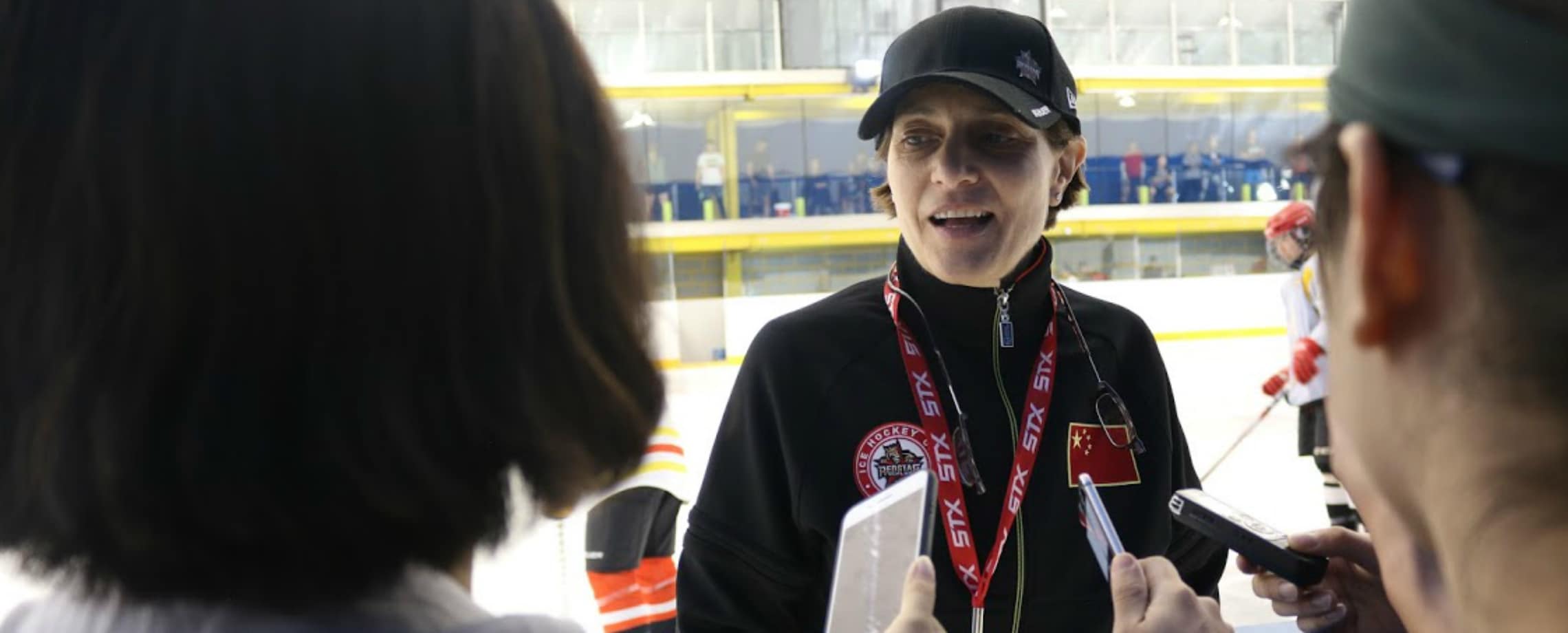 Athletic woman in cap being recorded by phones