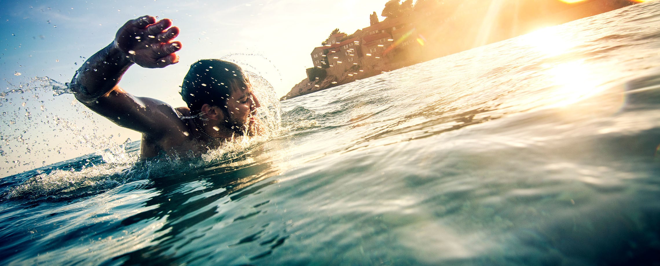 Young bearded man swimming in ocean