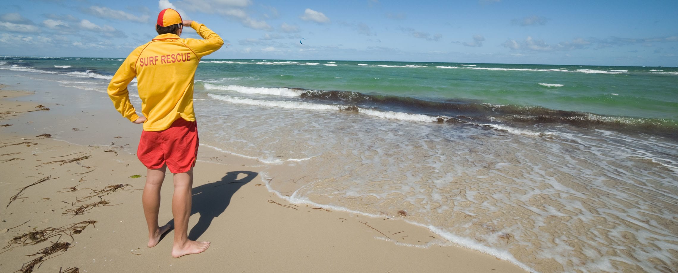 Lifeguard scanning the ocean while standing on a beach