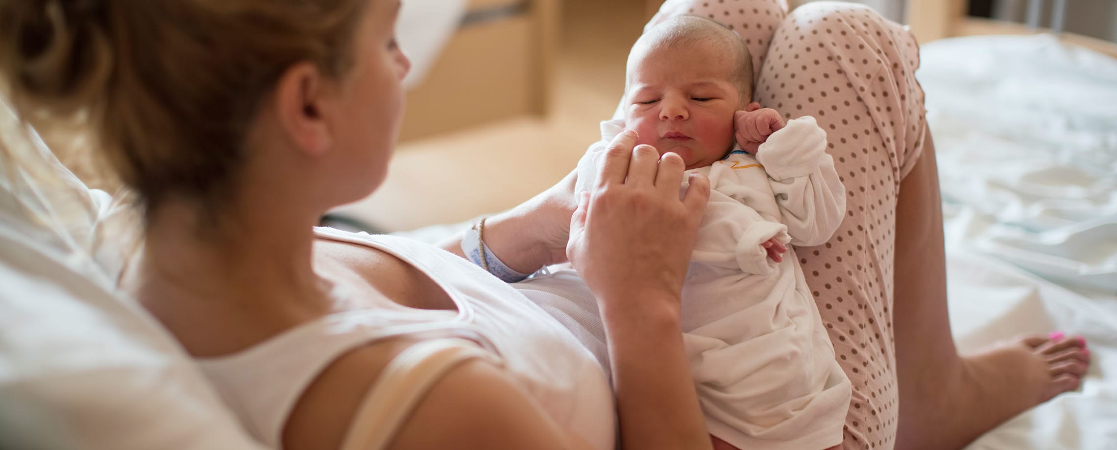 Newborn baby being held in mother's lap
