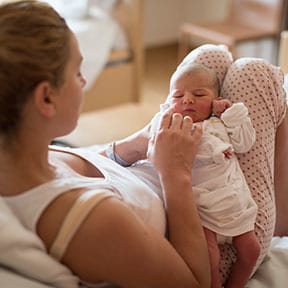 Mother lying in bed with her brand-new baby