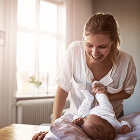Caucasian mother playing with baby on her lap