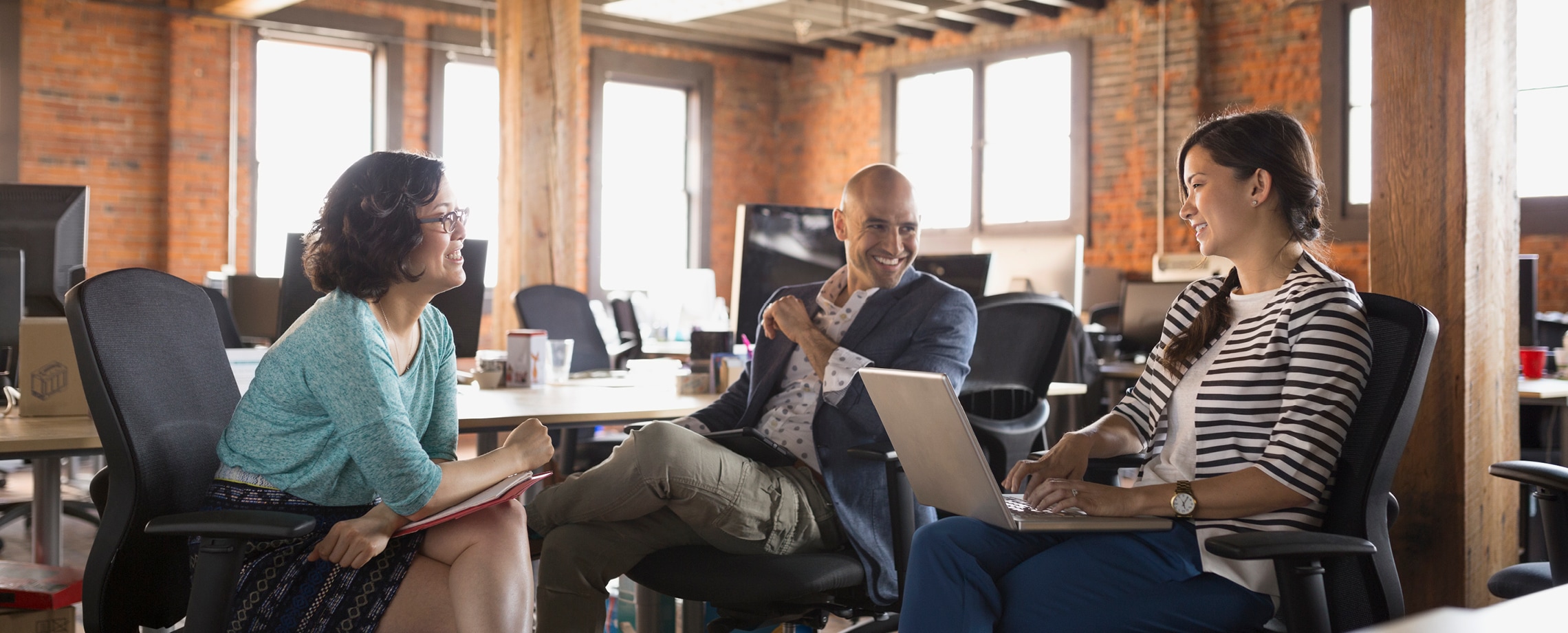 Business people of different races meeting in converted industrial building office