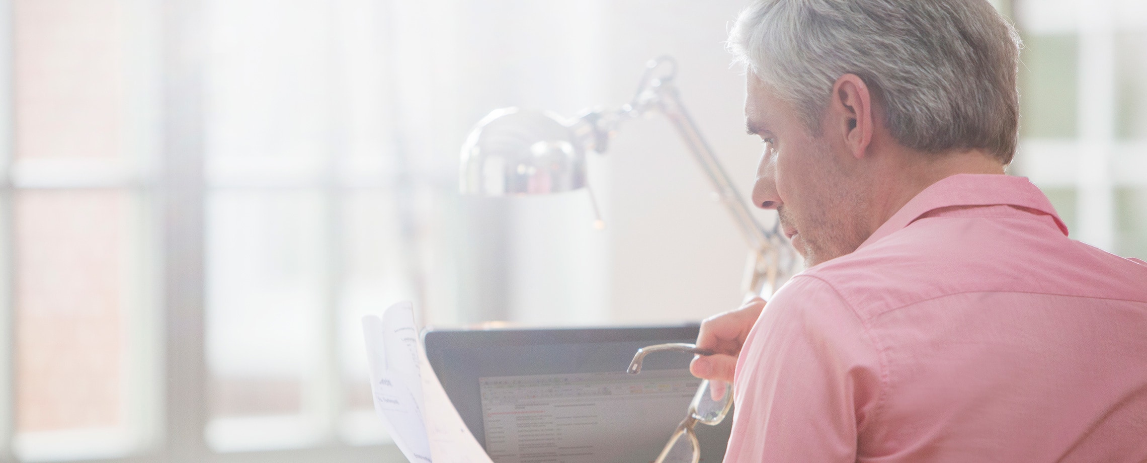 Close up of gray-haired man working on his laptop