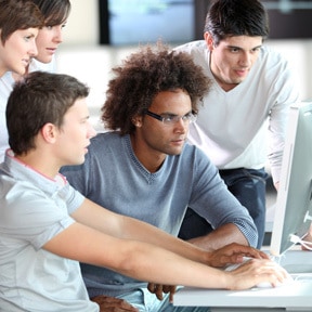 Group of young office multi-ethnic workers gathered around a laptop