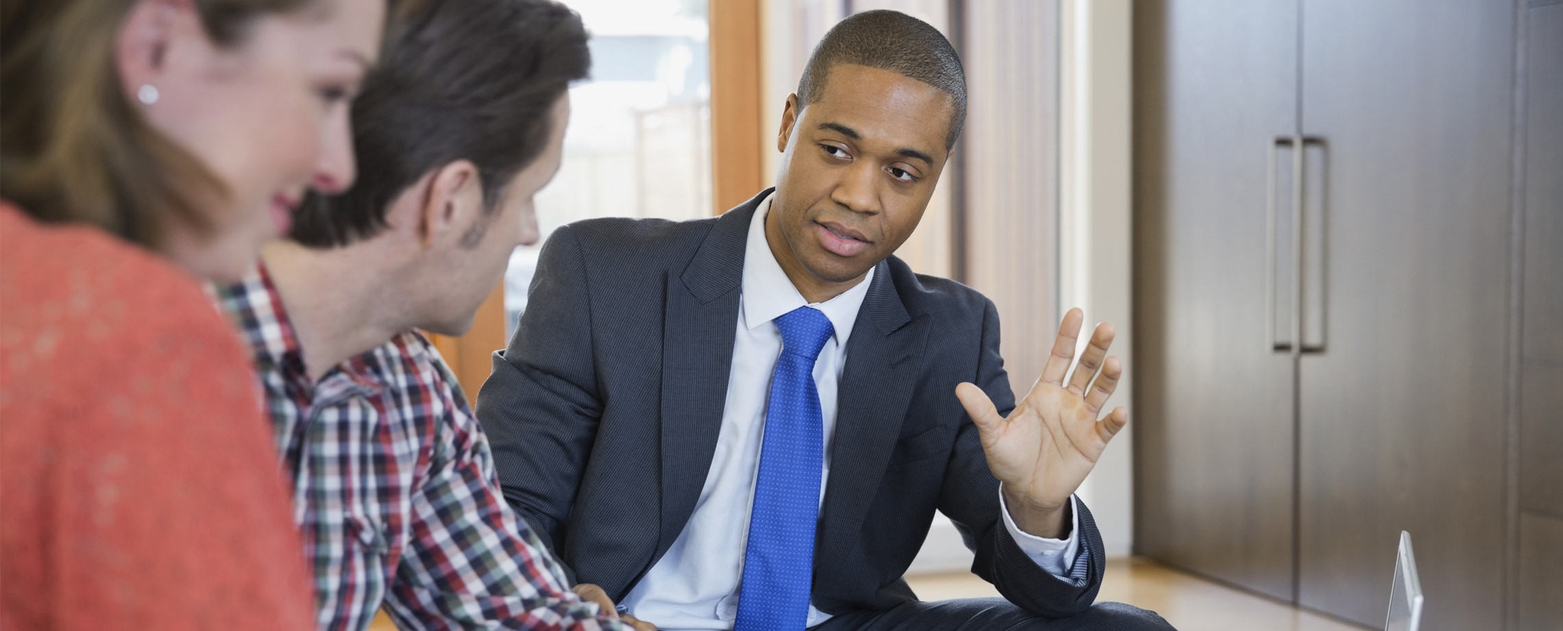 African-American businessman explaining something to Caucasian couple