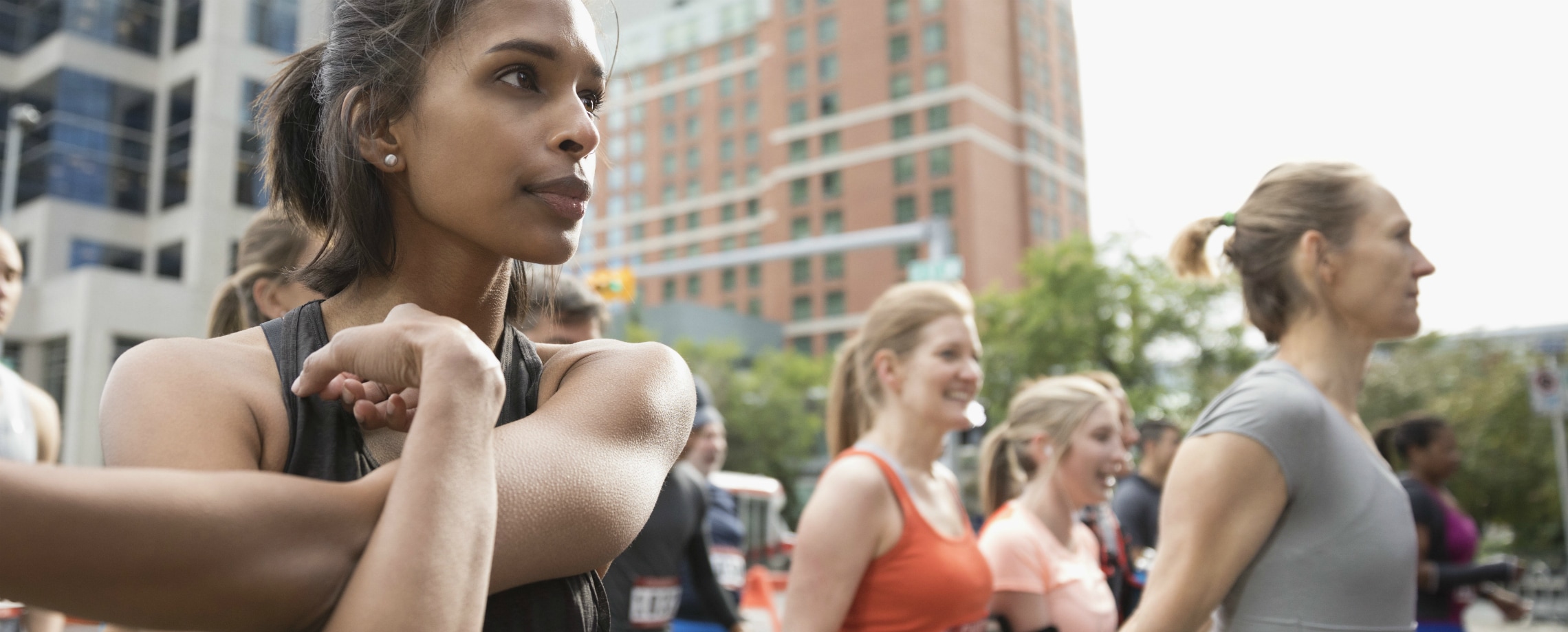 Close up of a group of people stretching before a road race