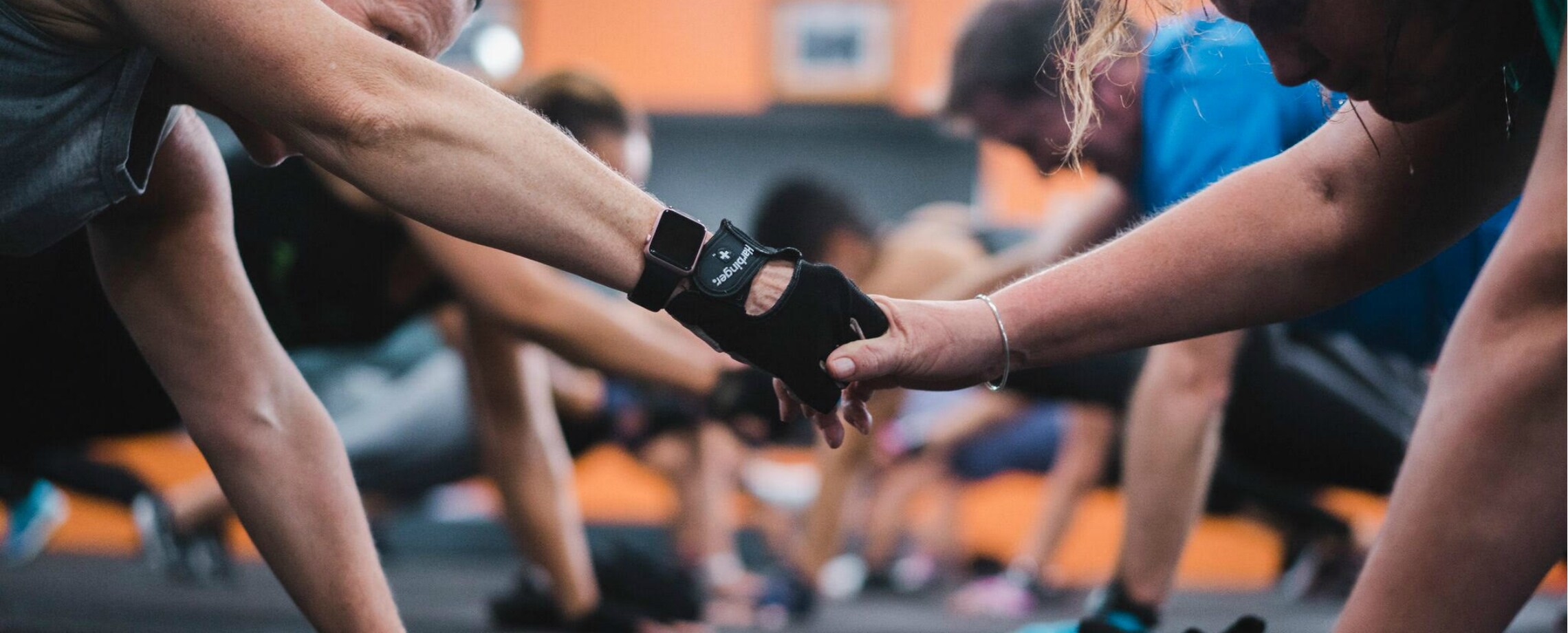 Group of men working out, on their hands and knees and shaking hands  with each other