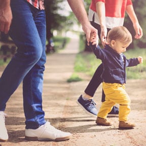 Parents teaching baby how to walk