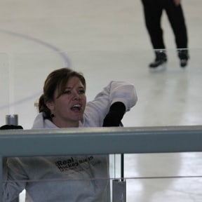 Hockey mom at game talking to fans in the stands