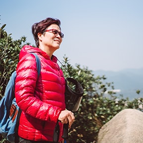 Middle-aged Asian-American woman hiking on a coastal trail