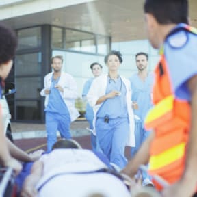 Hospital emergency team rushing to patient on wheeled stretcher