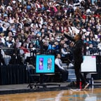 African-American male addressing a large crowd in an arena