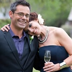 Middle aged couple at wedding smiling with woman holding champagne glass