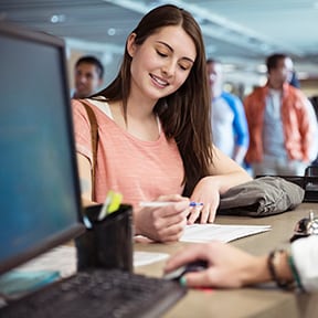 Young woman in queue filling out form at counter