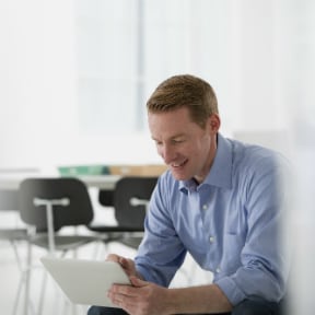 Thirty something Caucasian man sitting looking at tablet