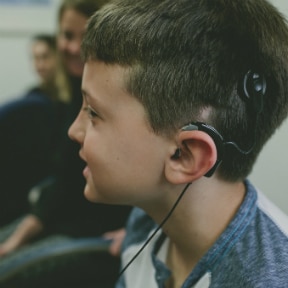 Young Caucasian boy wearing an external cochlear implant