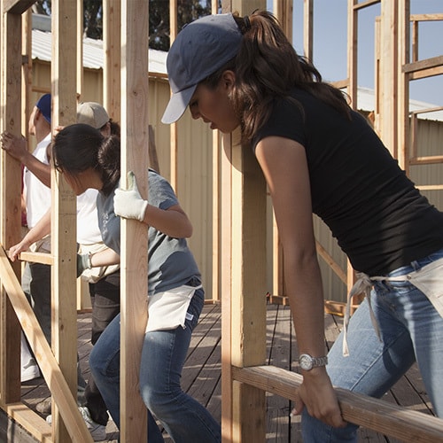 Multiple workers constructing frame wall