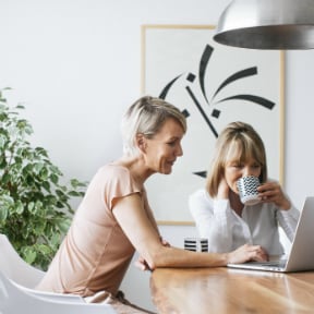 Two older Caucasian women looking at laptop together