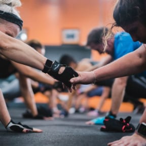 Group of men working out, on their hands and knees and shaking hands  with each other