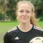 Caucasian female student with soccer ball