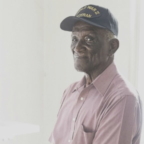 Older African-American man wearing World War II Veteran hat