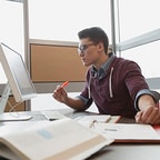 Young worker with computer and pen